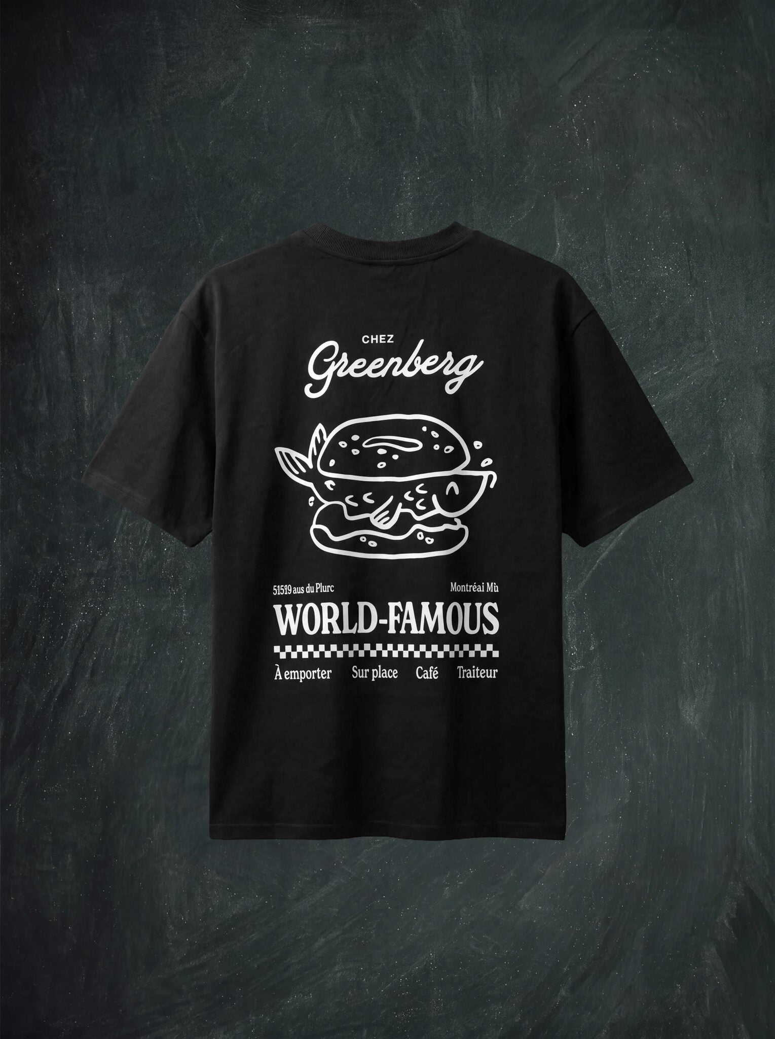 A black short-sleeve t-shirt with a white graphic print on the back, featuring a burger illustration and the text 'Chez Greenberg' and 'WORLD-FAMOUS', displayed against a dark textured background.